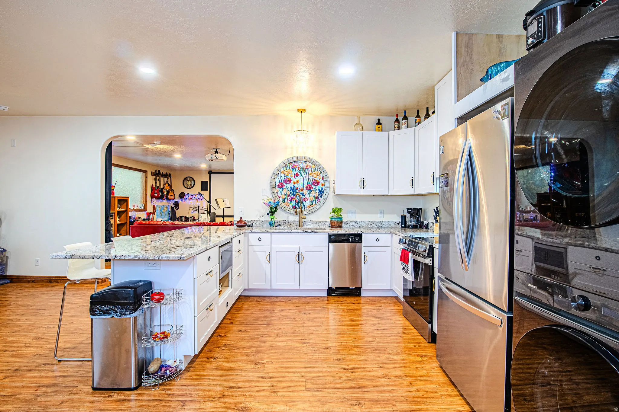 Modern kitchen with wood-finish flooring and white cabinetry