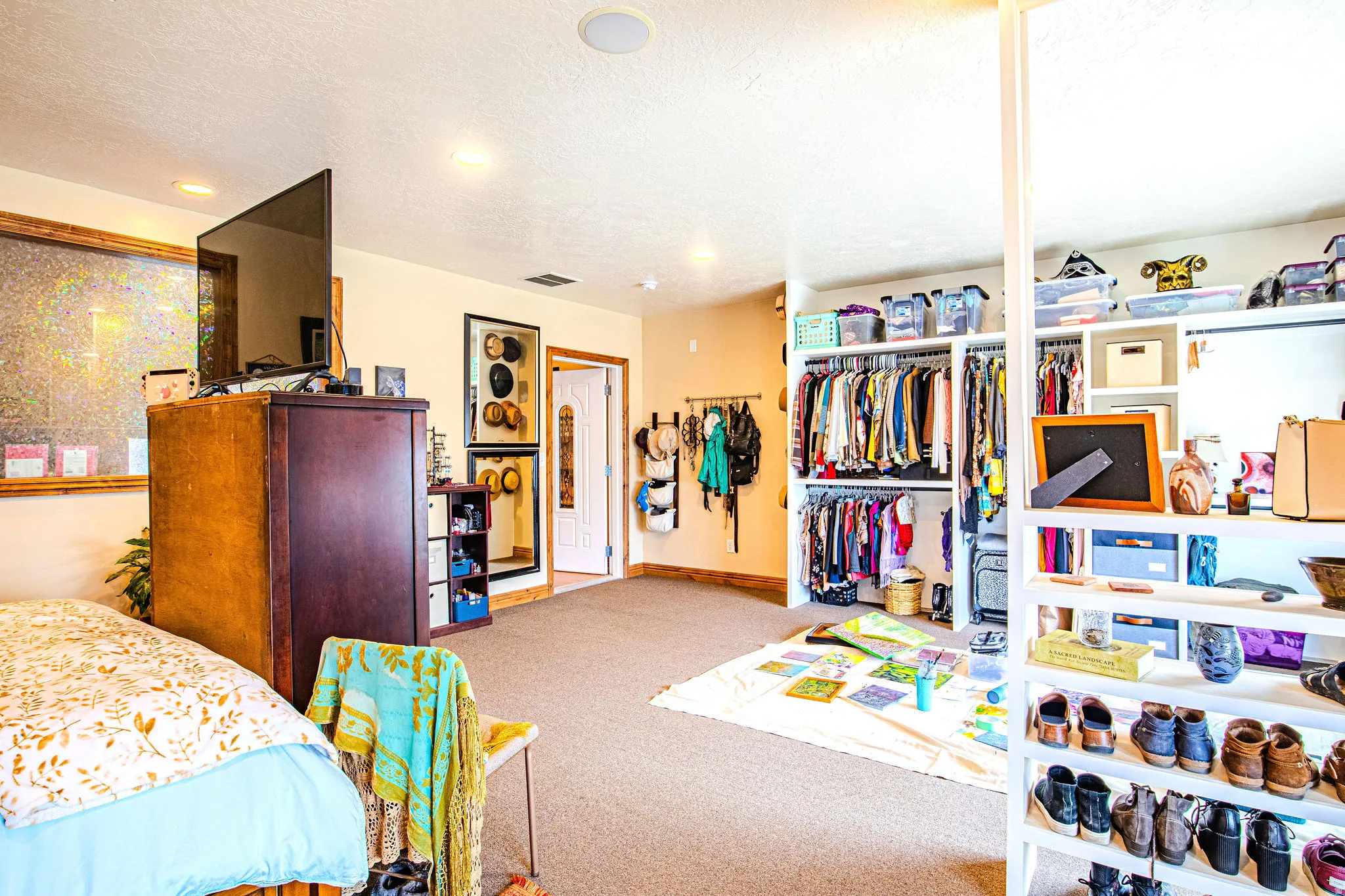Spacious interior room featuring carpet flooring, recessed lighting, and a built-in closet system with shelving and hanging rods