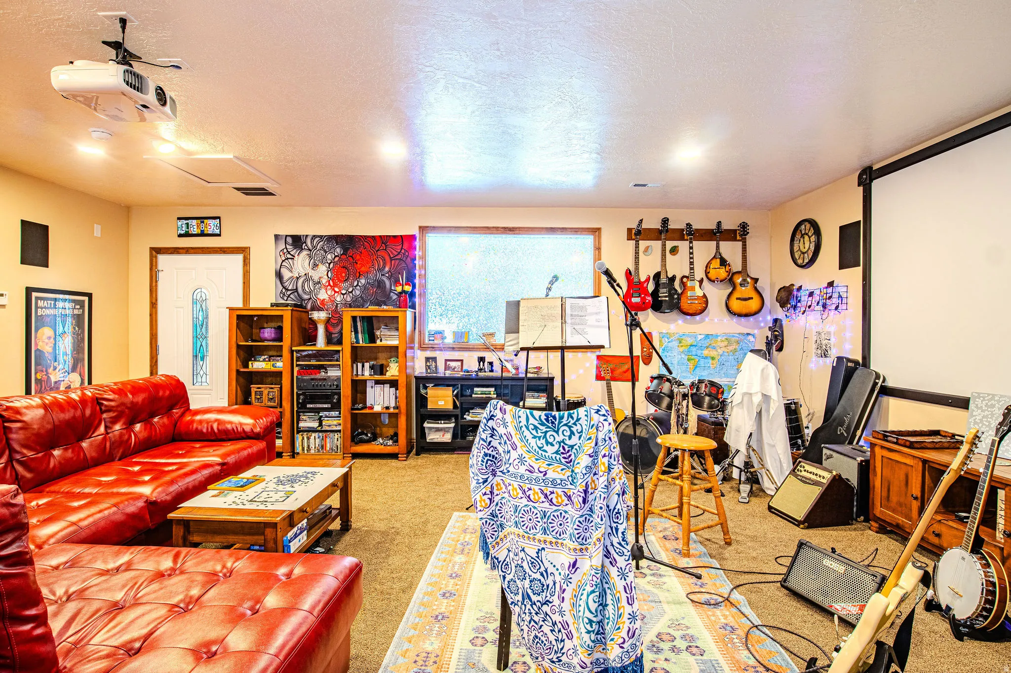Spacious entertainment room featuring recessed lighting, a ceiling-mounted projector, and a large projection screen