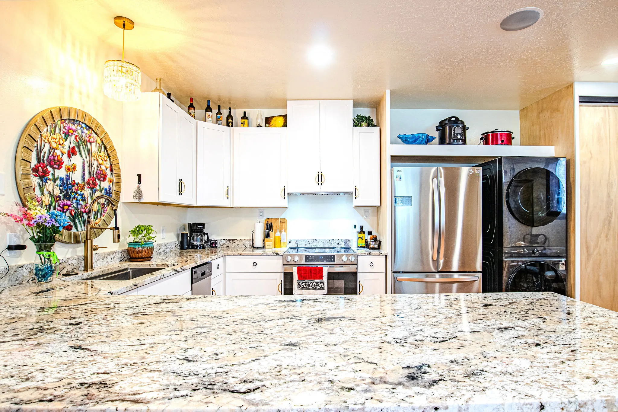 Kitchen showcasing granite countertops, white cabinetry, stainless steel appliances, a built-in sink, and overhead recessed lighting