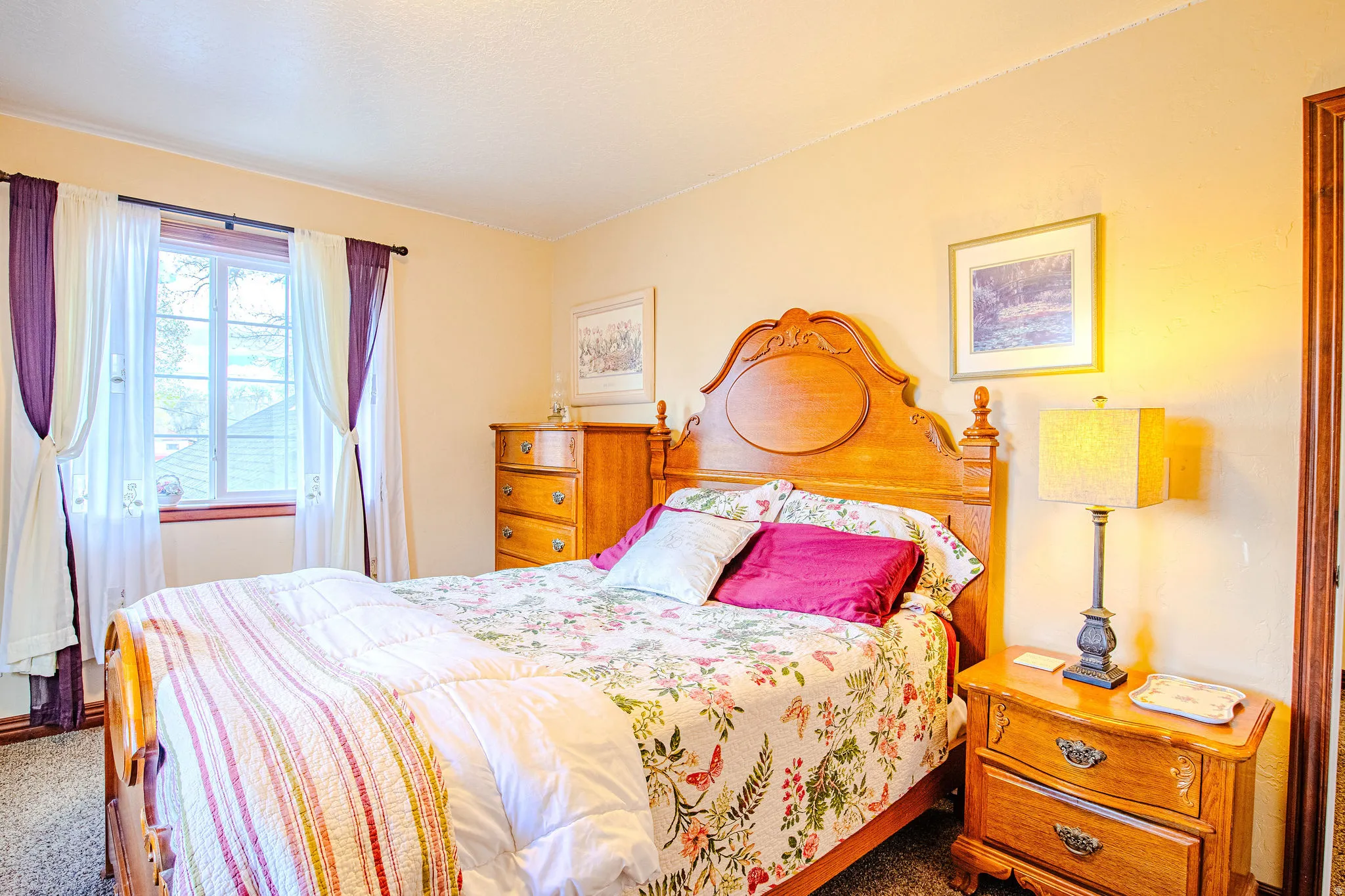 Carpeted second bedroom with a double-pane window featuring wood trim