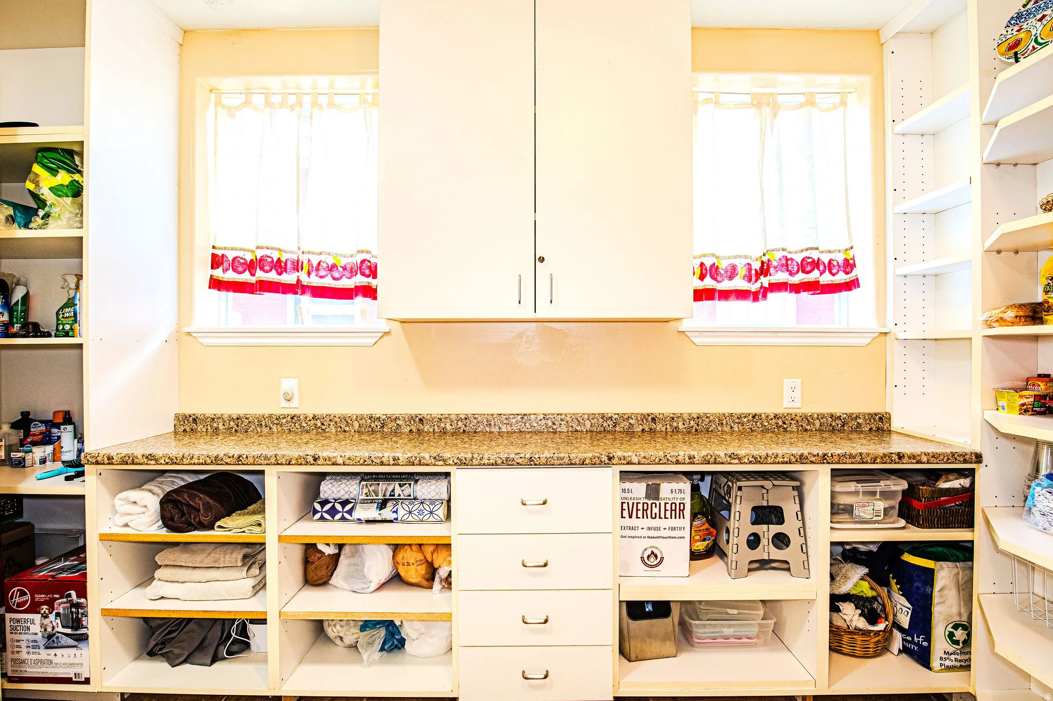 Built-in cabinetry featuring a speckled countertop, four central drawers, and open shelving