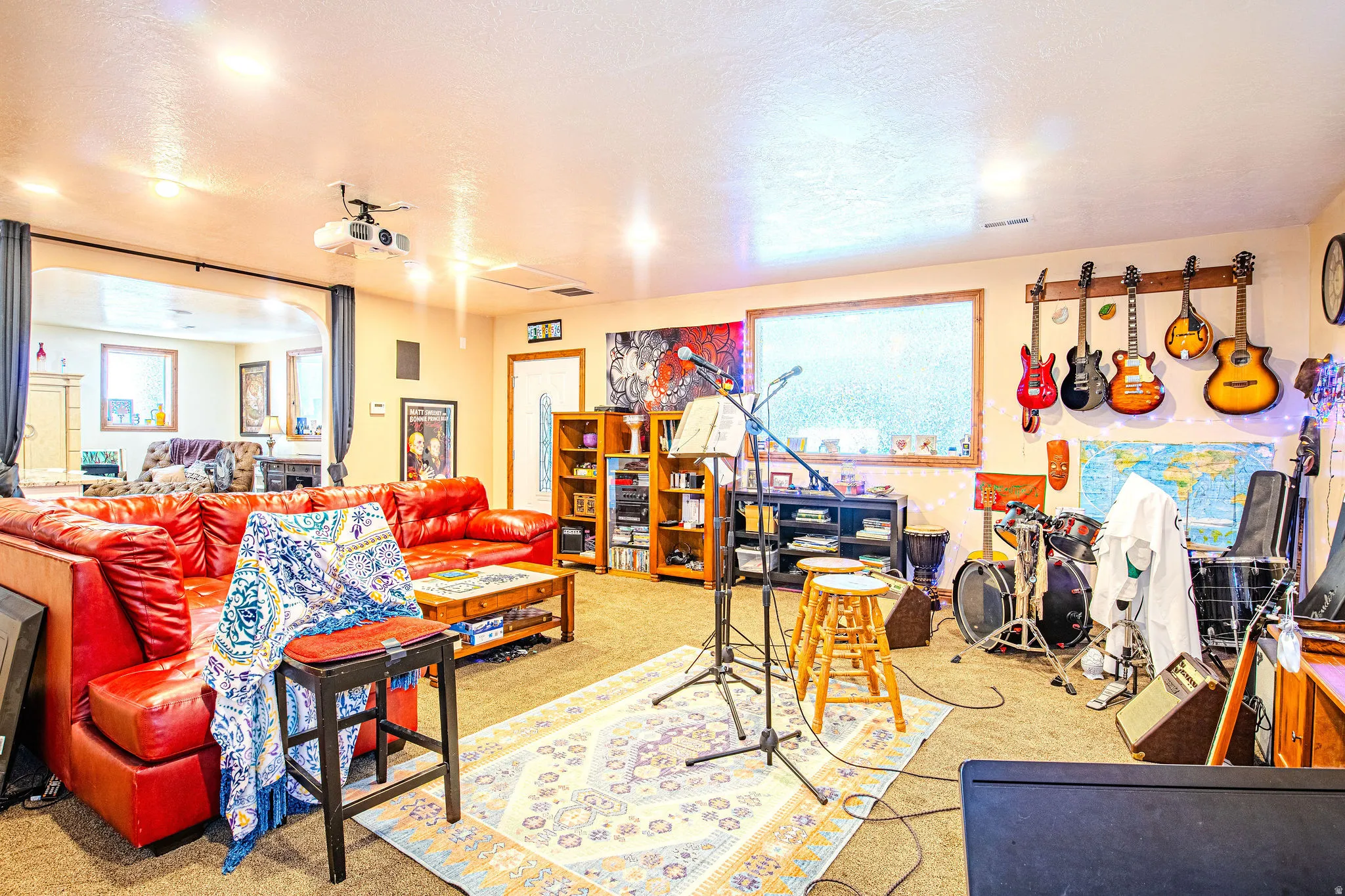 Spacious entertainment area featuring recessed lighting, a ceiling-mounted projector, and carpeted flooring