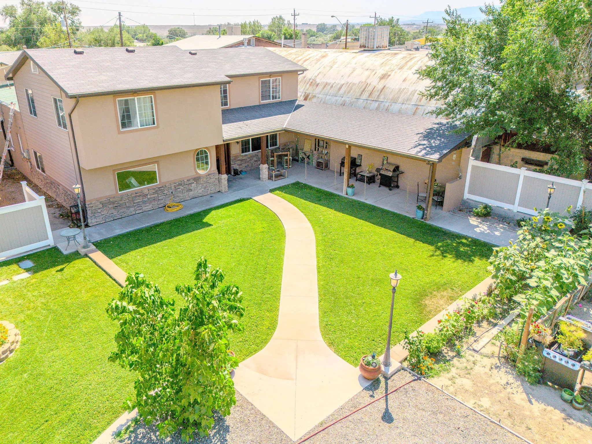 Exterior featuring stucco siding, stone-finish accents, and a covered patio with exposed beam details