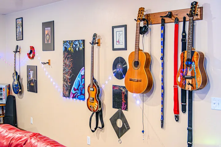 Light beige painted walls with mounted guitars and framed artwork