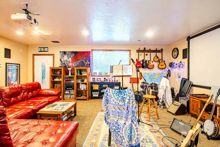 Spacious entertainment room featuring recessed lighting, a ceiling-mounted projector, and a large projection screen