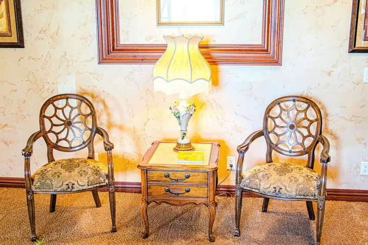 Textured wall finish featuring decorative wall art, wood-finish baseboards, and carpet flooring