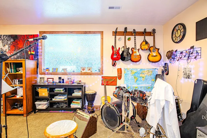 Spacious room featuring carpeting, a large window with wood trim, and light beige wall paint
