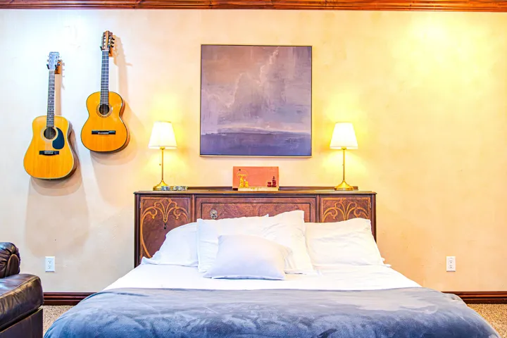 Decorative antique furniture featuring intricate carvings behind extra guest bed.