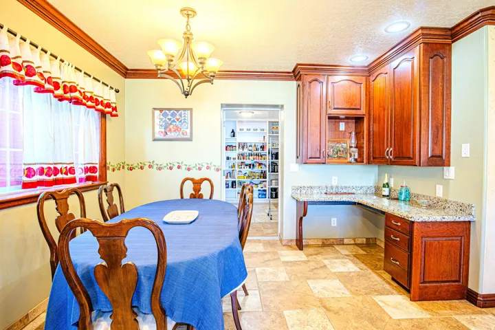Dining area featuring warm wood crown molding, a decorative chandelier, and recessed lighting