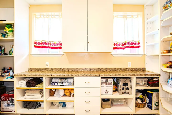 Built-in cabinetry featuring a speckled countertop, four central drawers, and open shelving