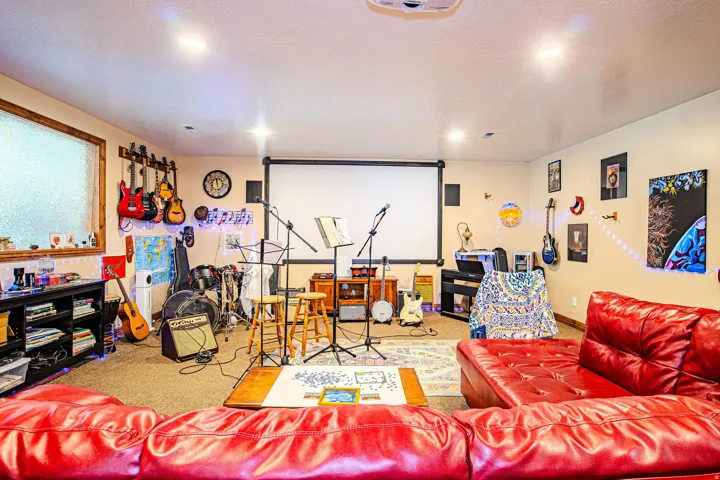 Spacious entertainment room featuring recessed lighting, a projection screen, and textured carpet flooring