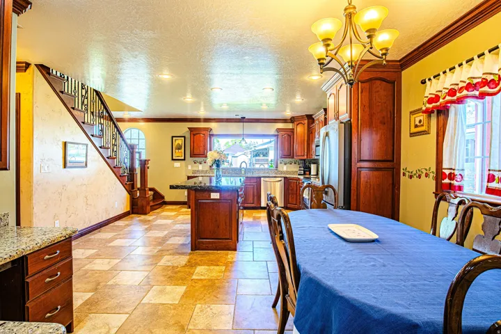 Open concept interior featuring tiled flooring, granite countertops, and rich wood cabinetry