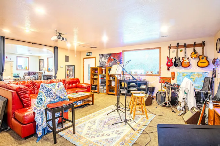 Spacious entertainment area featuring recessed lighting, a ceiling-mounted projector, and carpeted flooring