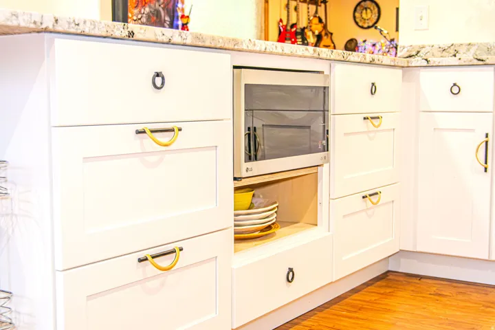White cabinetry with varied pull styles, including ring pulls and D-pulls