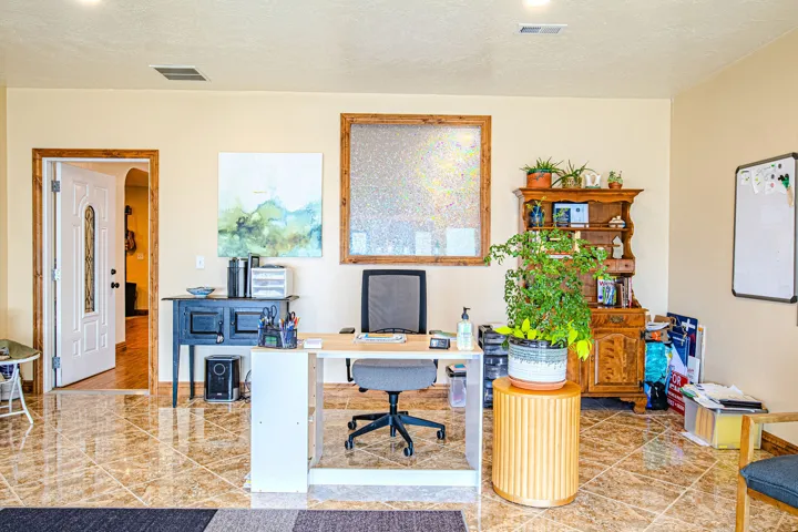 Tiled flooring extending throughout, featuring a white paneled door with an arched glass insert and a wood-framed window with textured glass