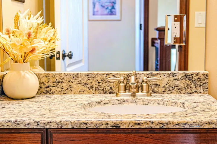 Granite countertop with an integrated undermount sink and brushed nickel faucet in second bathroom