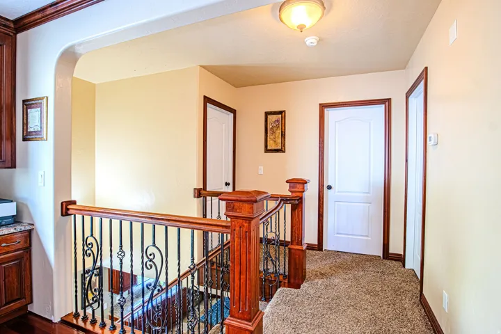 Staircase with wrought iron balusters and rich wood handrails
