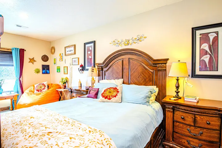 Bedroom featuring a wood-finish bed frame, wood-finish nightstand, recessed lighting, and a window with blinds