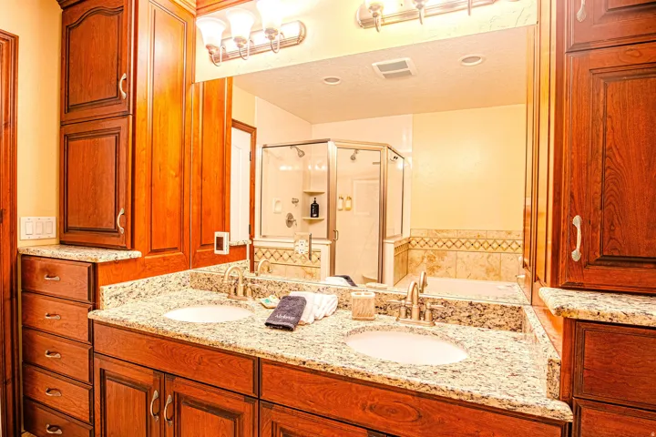 Double vanity in Master Bathroom featuring granite countertops and undermount sinks