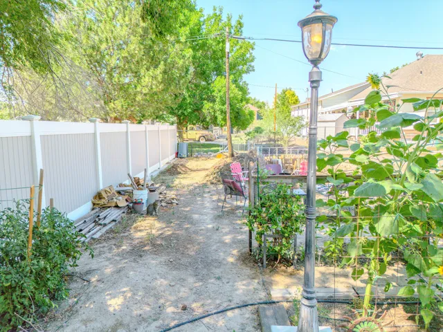 Backyard area featuring a perimeter fence and mature trees