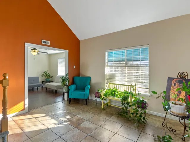 Vaulted ceilings over tile flooring with a transom window and white blinds