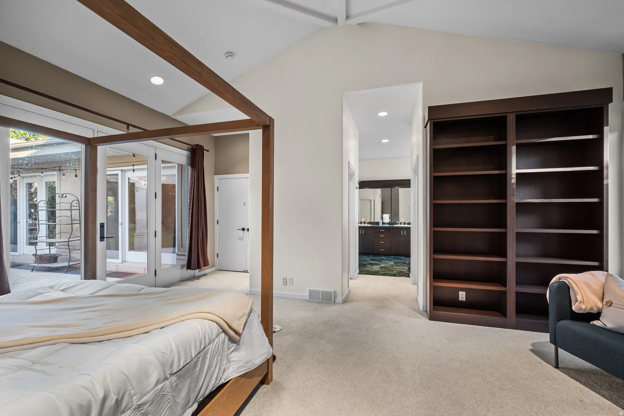 Carpeted bedroom with vaulted ceiling and recessed lighting