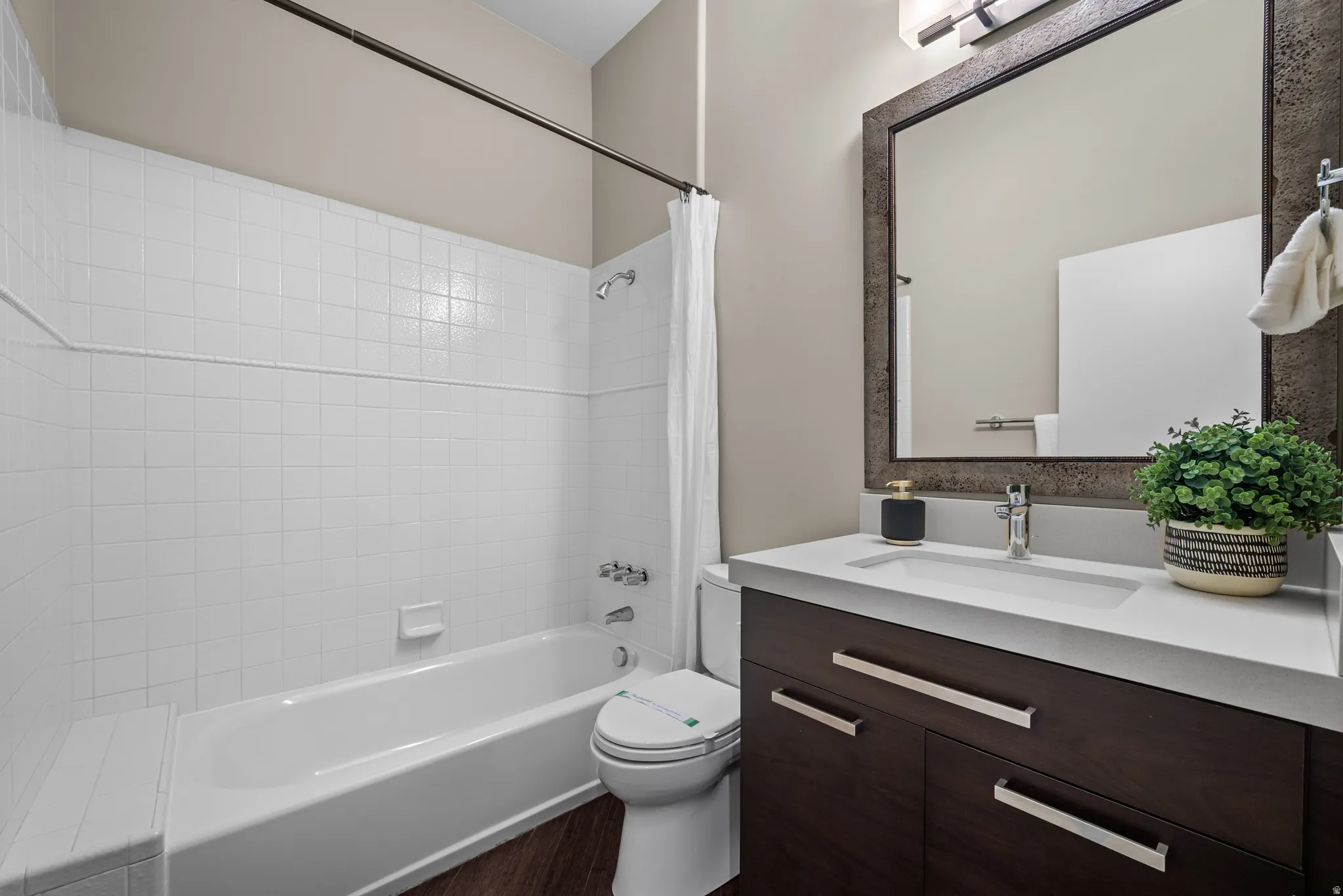 Bathroom featuring a dark wood-finish vanity with a light countertop and an integrated sink