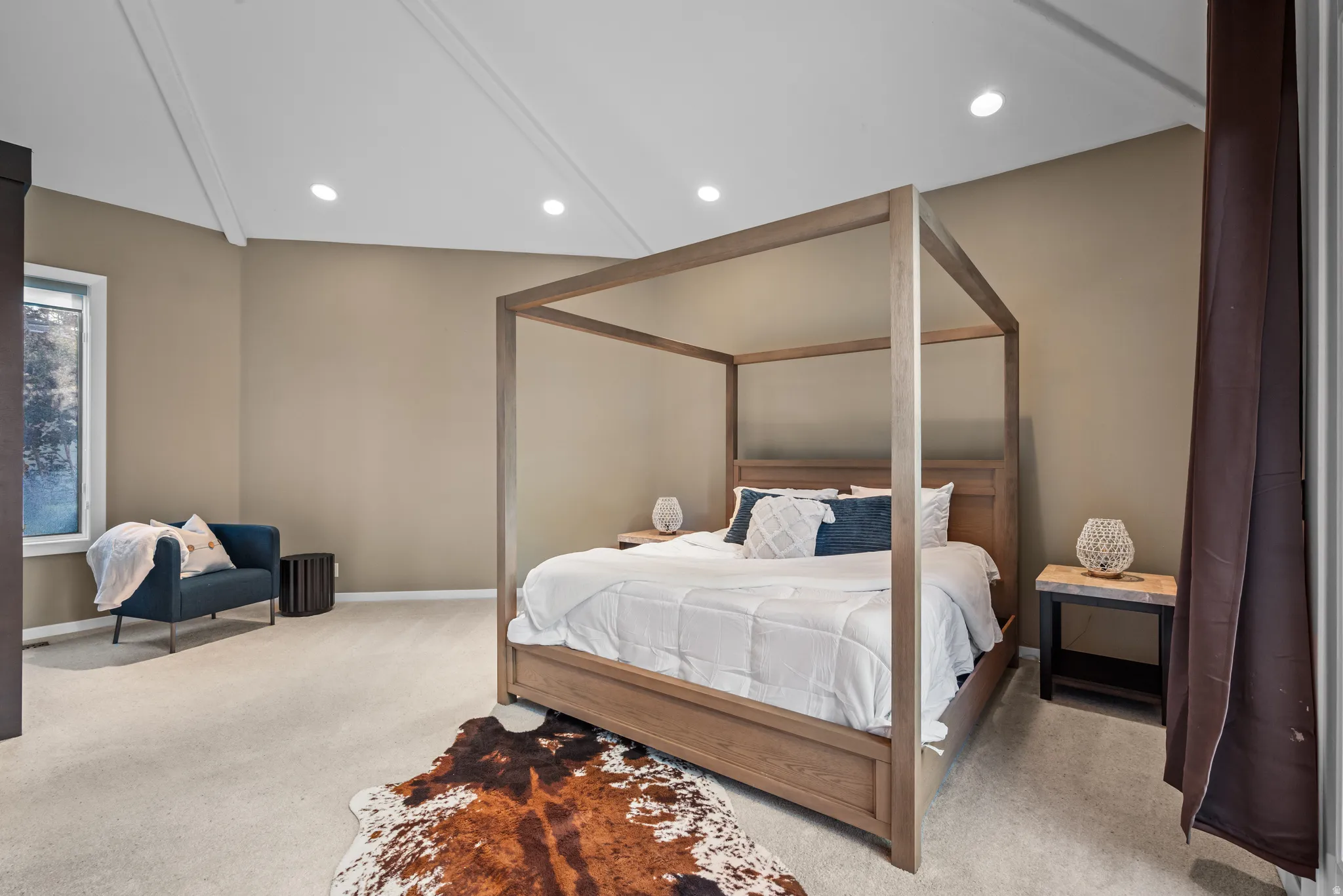 Spacious bedroom featuring vaulted ceilings, recessed lighting, neutral wall tones, and plush carpeting