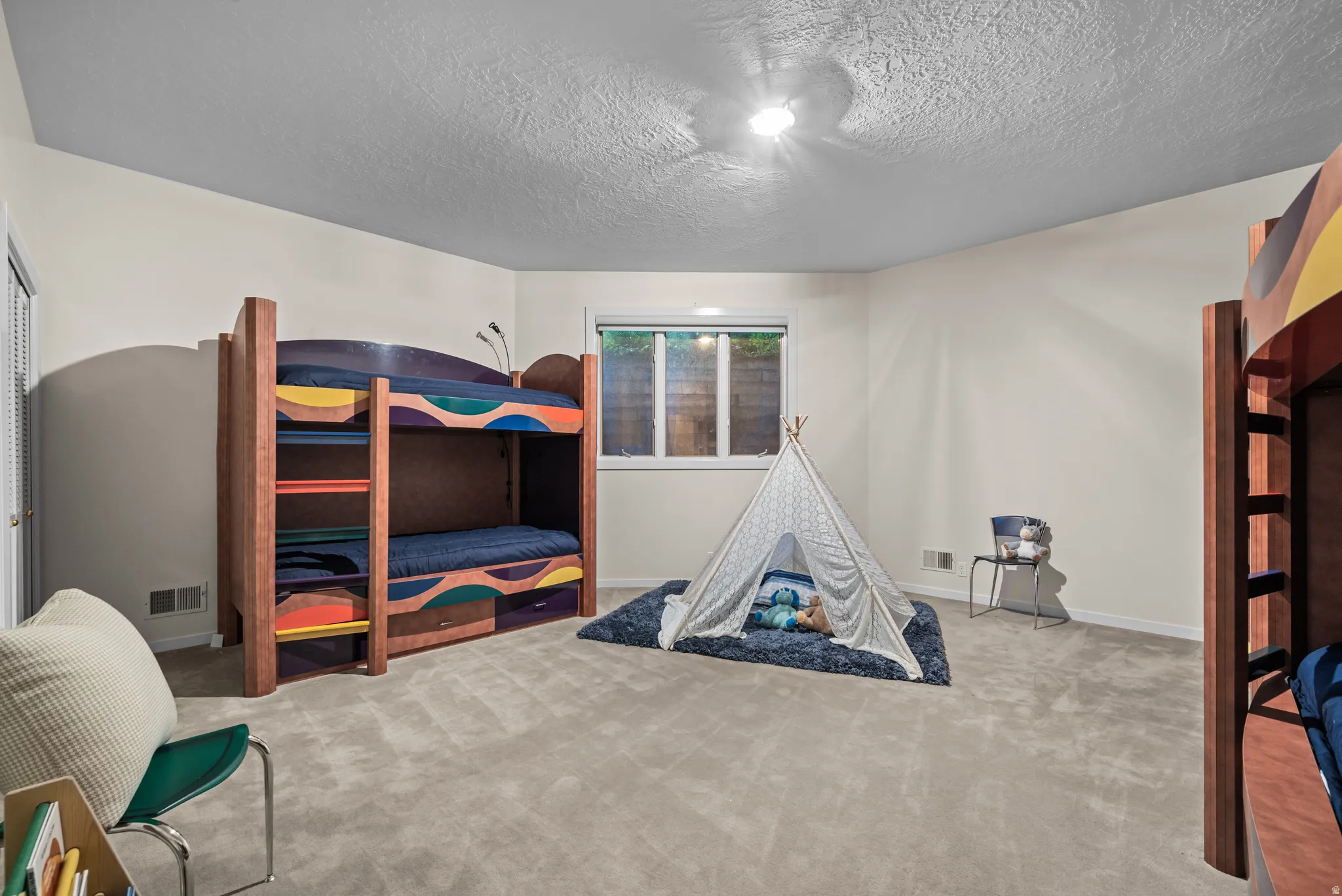 Spacious room featuring light-colored walls and wall-to-wall carpeting
