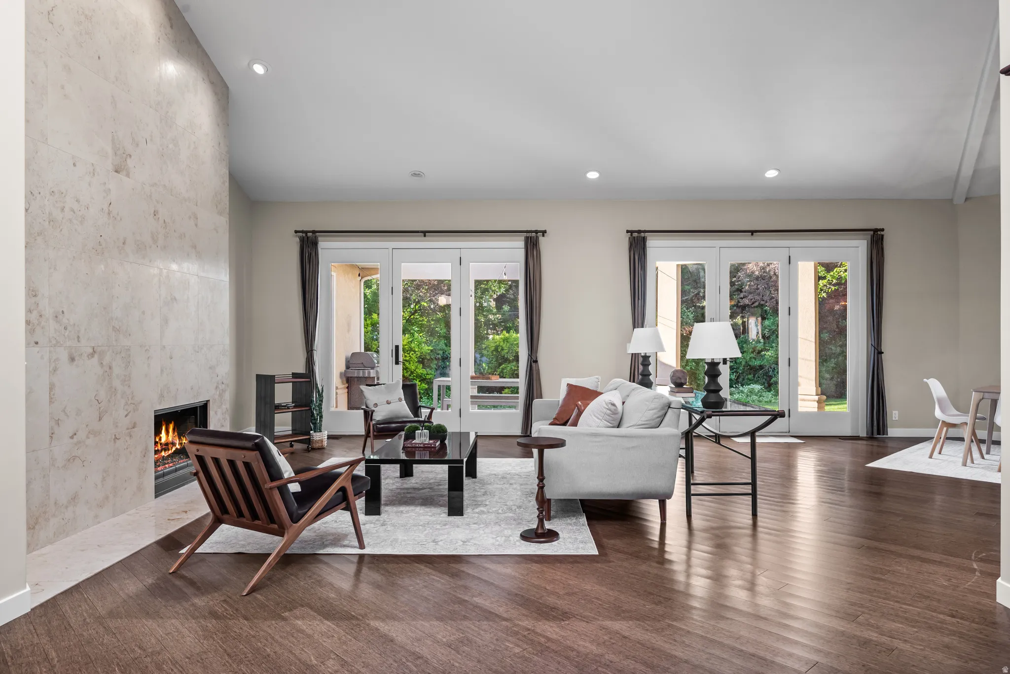 Living space featuring wood-finish flooring, a full-height stone-clad fireplace, and recessed lighting