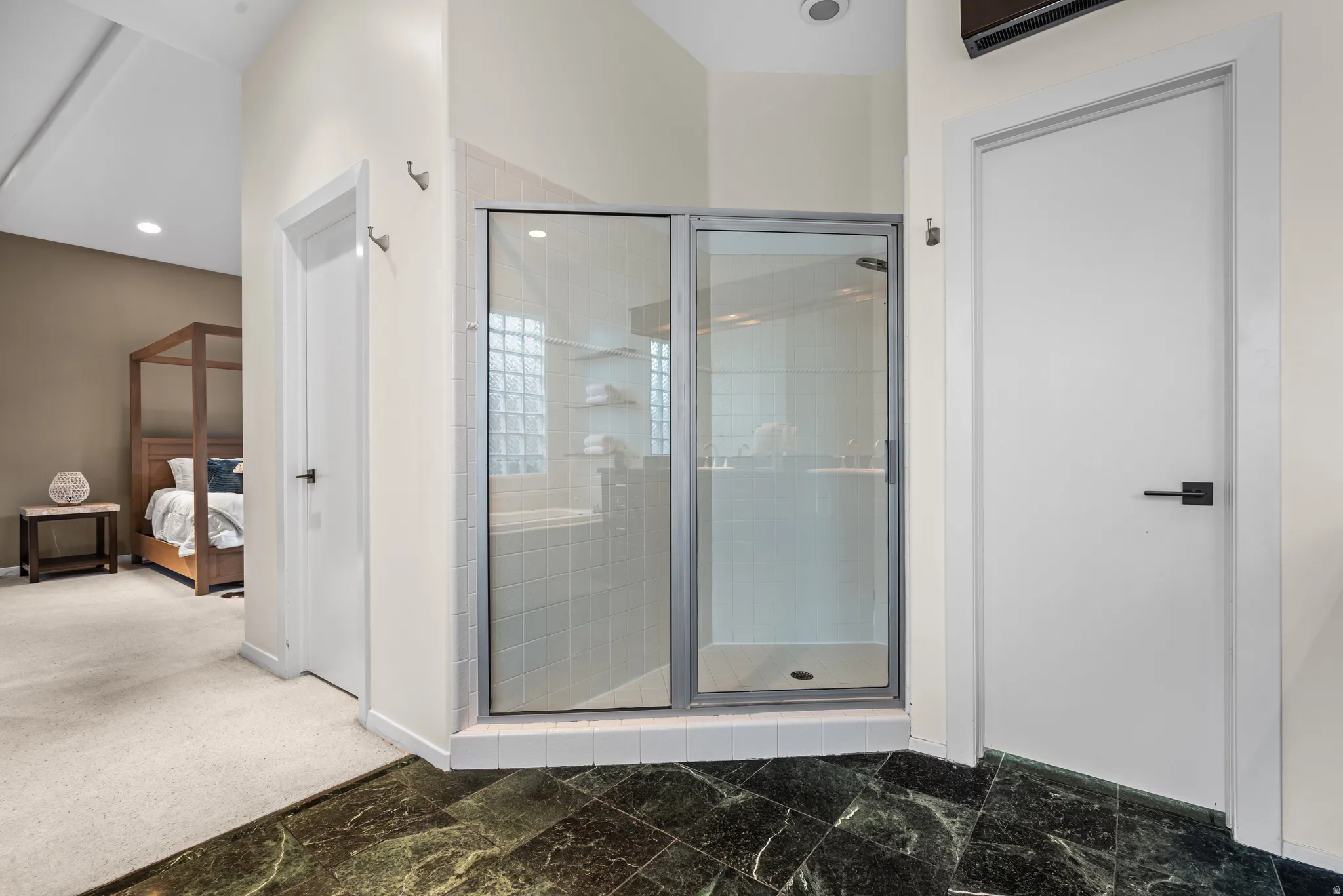 Glass-enclosed shower with tile surround and glass block window