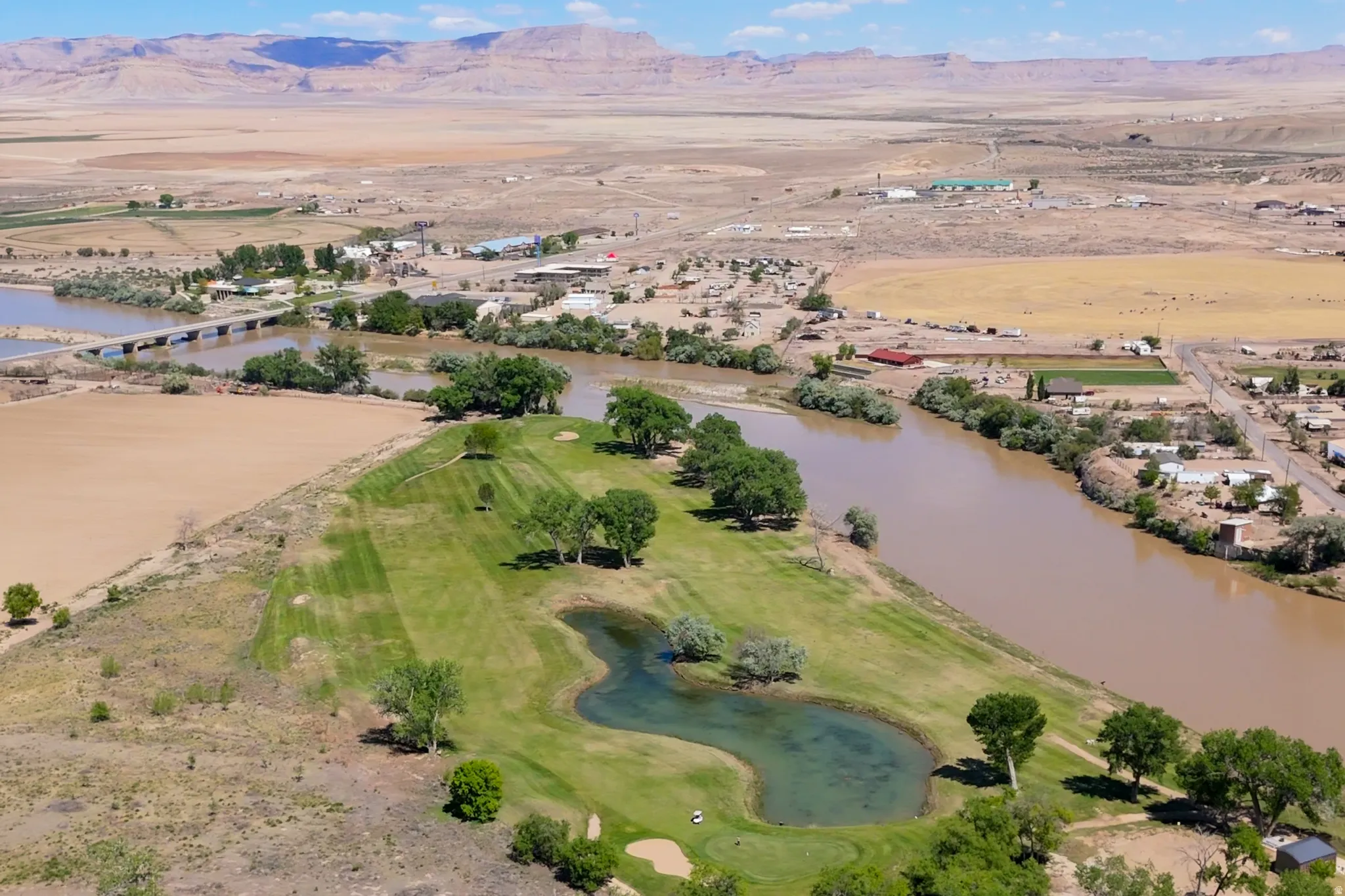 Expansive golf course featuring manicured fairways, mature trees, and a water hazard
