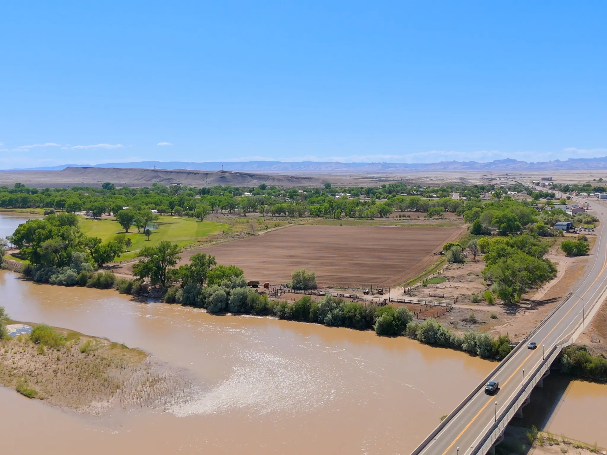 Expansive land parcel featuring direct river frontage and a large cultivated field
