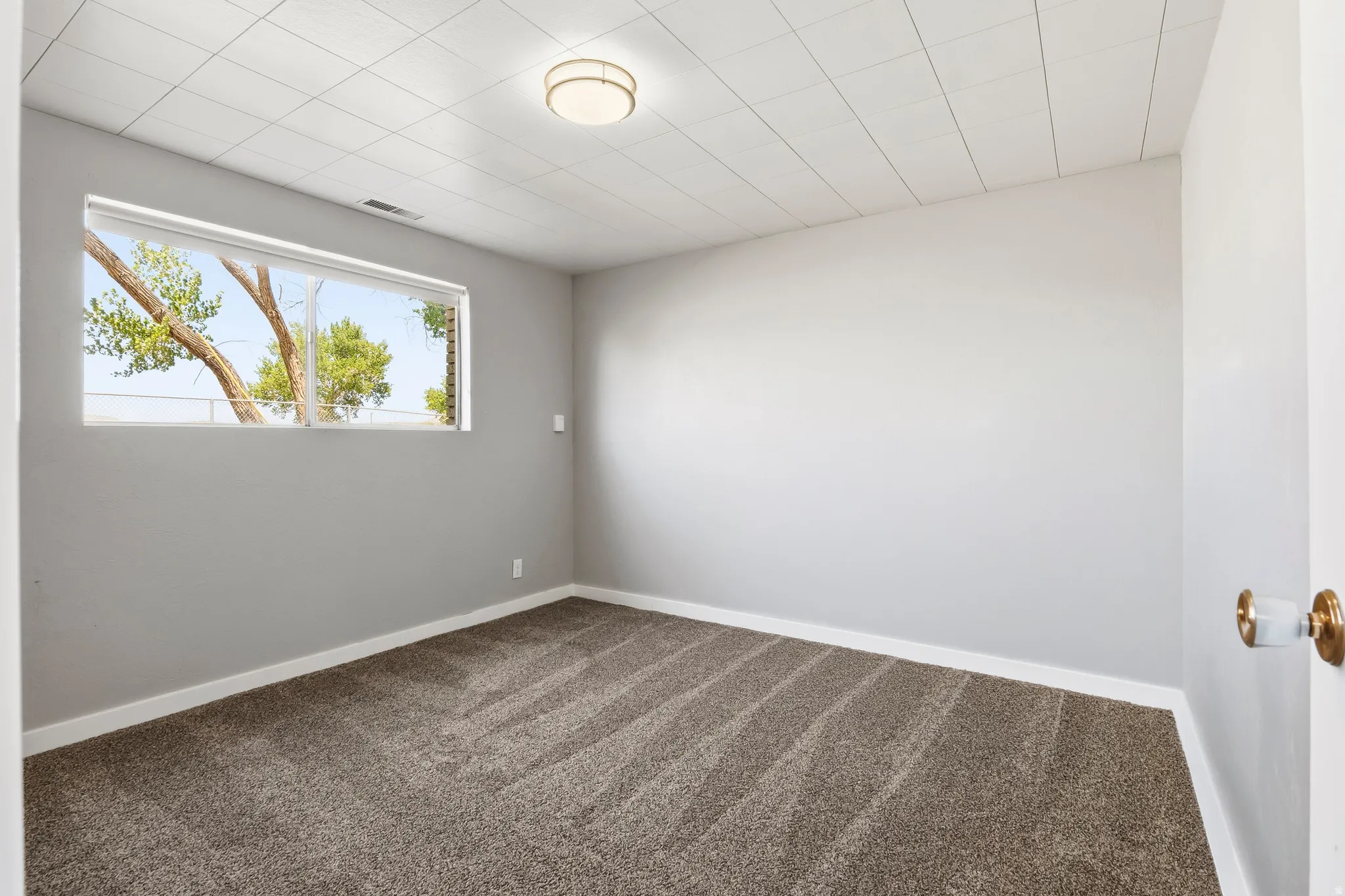 Neutral tone walls with white trim, complemented by a large window with natural light