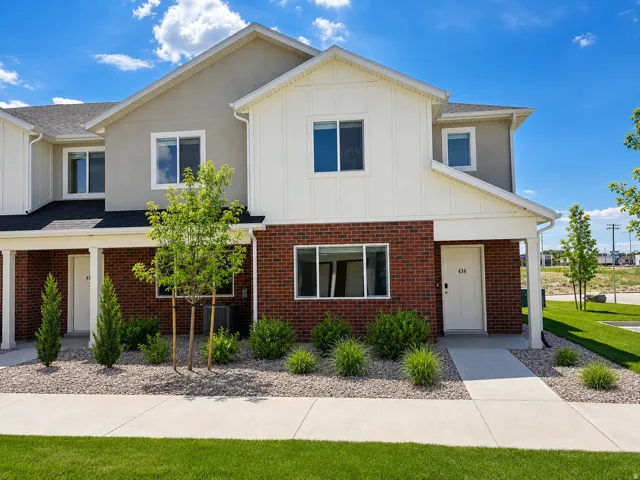 Contemporary townhome exterior featuring red brick and light gray stucco