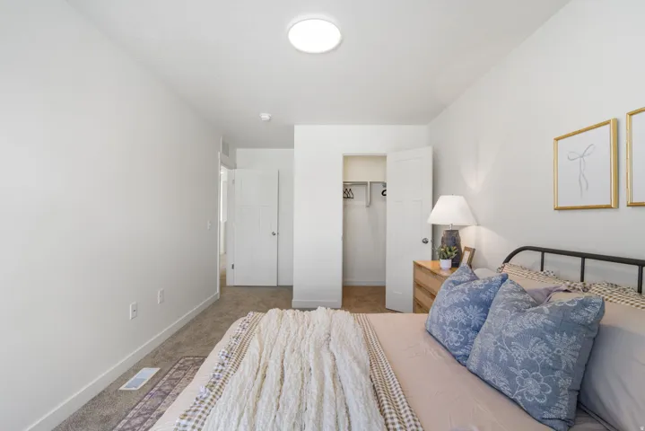 Carpeted room featuring a ceiling-mounted light fixture, white walls, and a closet with bifold doors