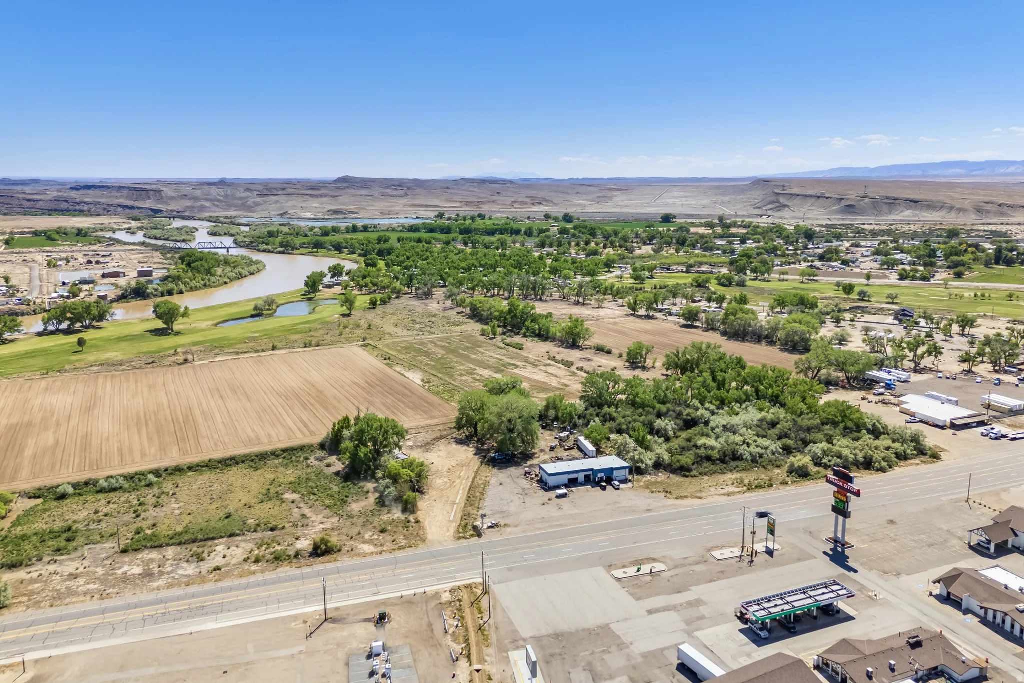 Expansive land parcel featuring open fields, natural vegetation, and a clear sky