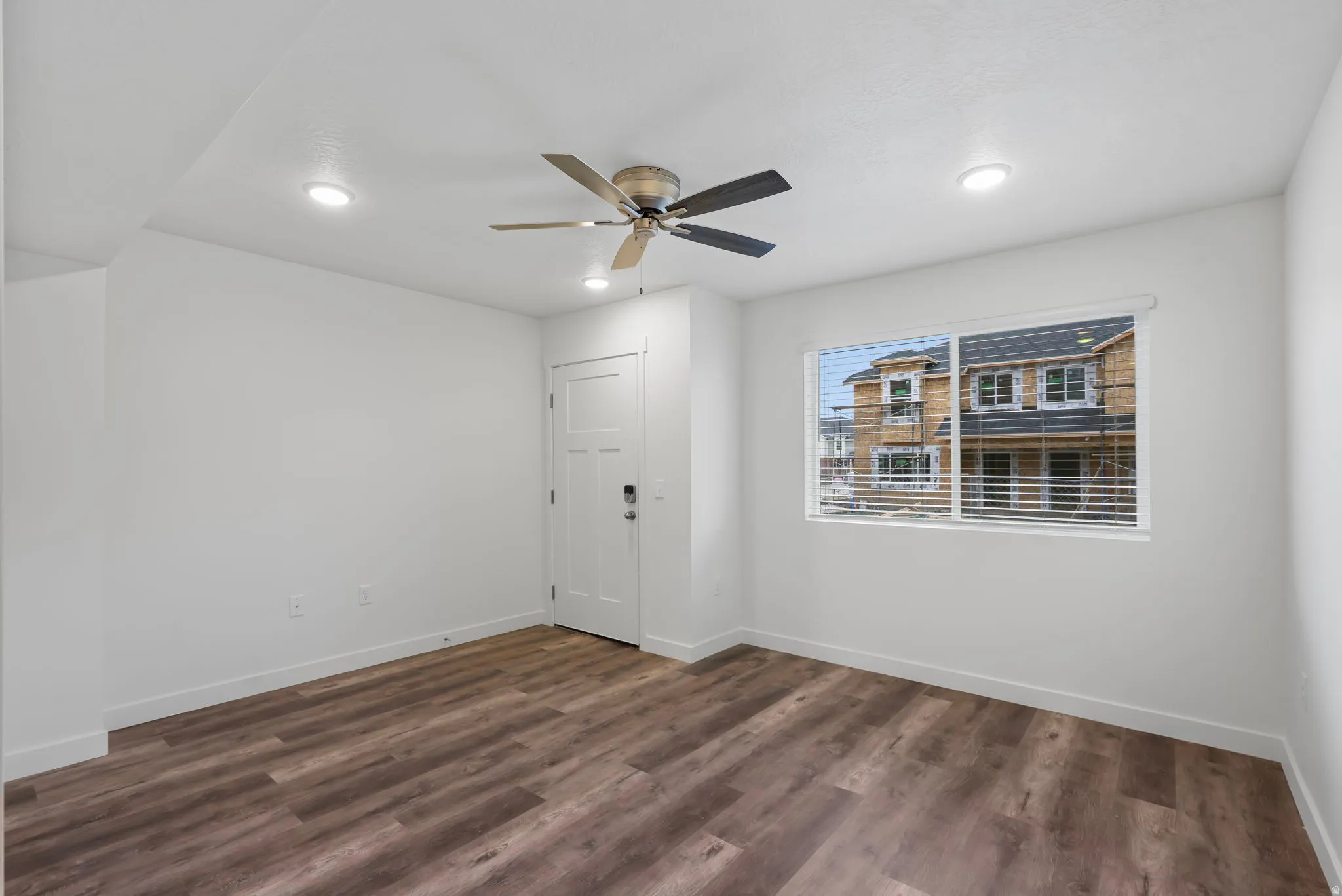 Bright interior space featuring wood-finish flooring and a contemporary ceiling fan