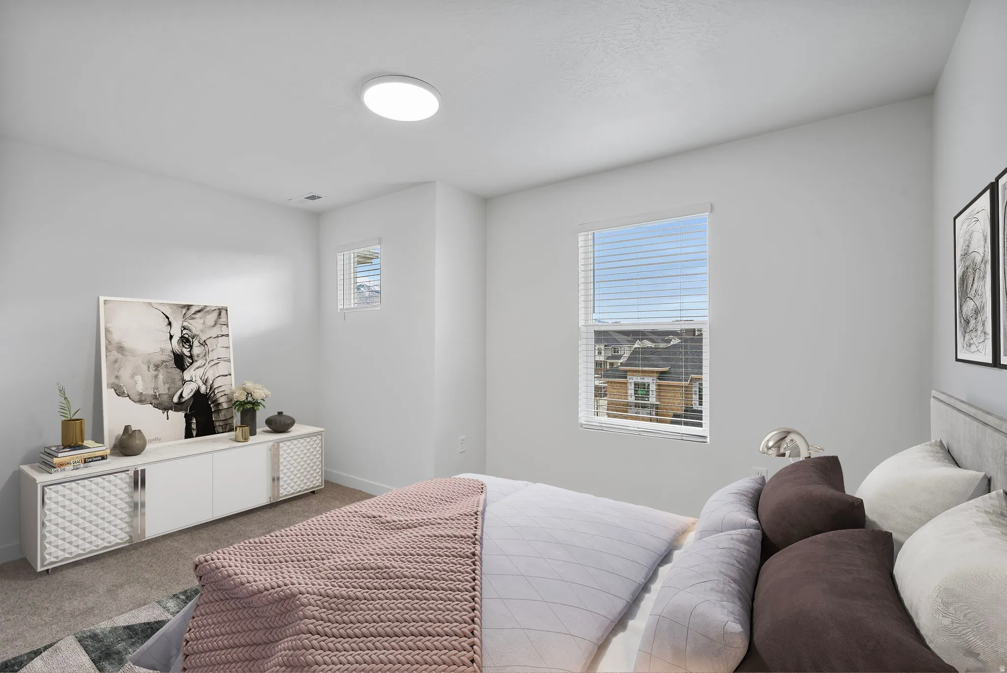 Carpeted room featuring light-toned walls, a flush-mount ceiling light, and two windows with horizontal blinds