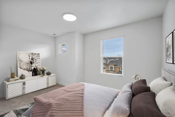 Carpeted room featuring light-toned walls, a flush-mount ceiling light, and two windows with horizontal blinds