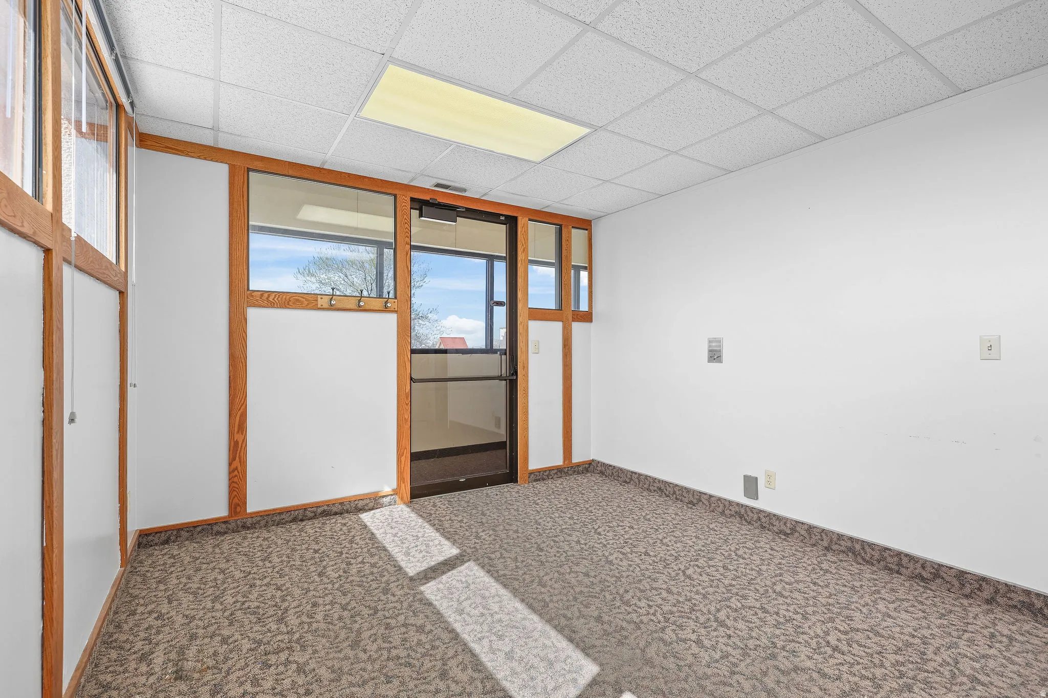 Carpeted room featuring a drop ceiling with recessed lighting