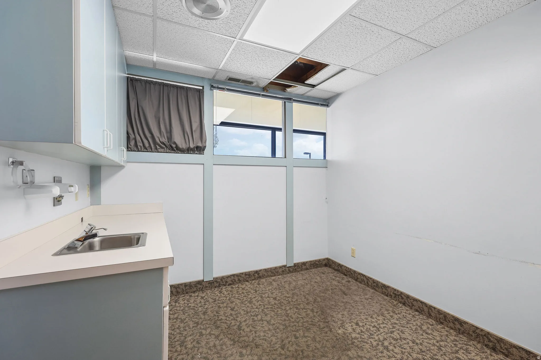 Functional workspace with built-in cabinetry, an integrated sink, and an overhead lighting fixture