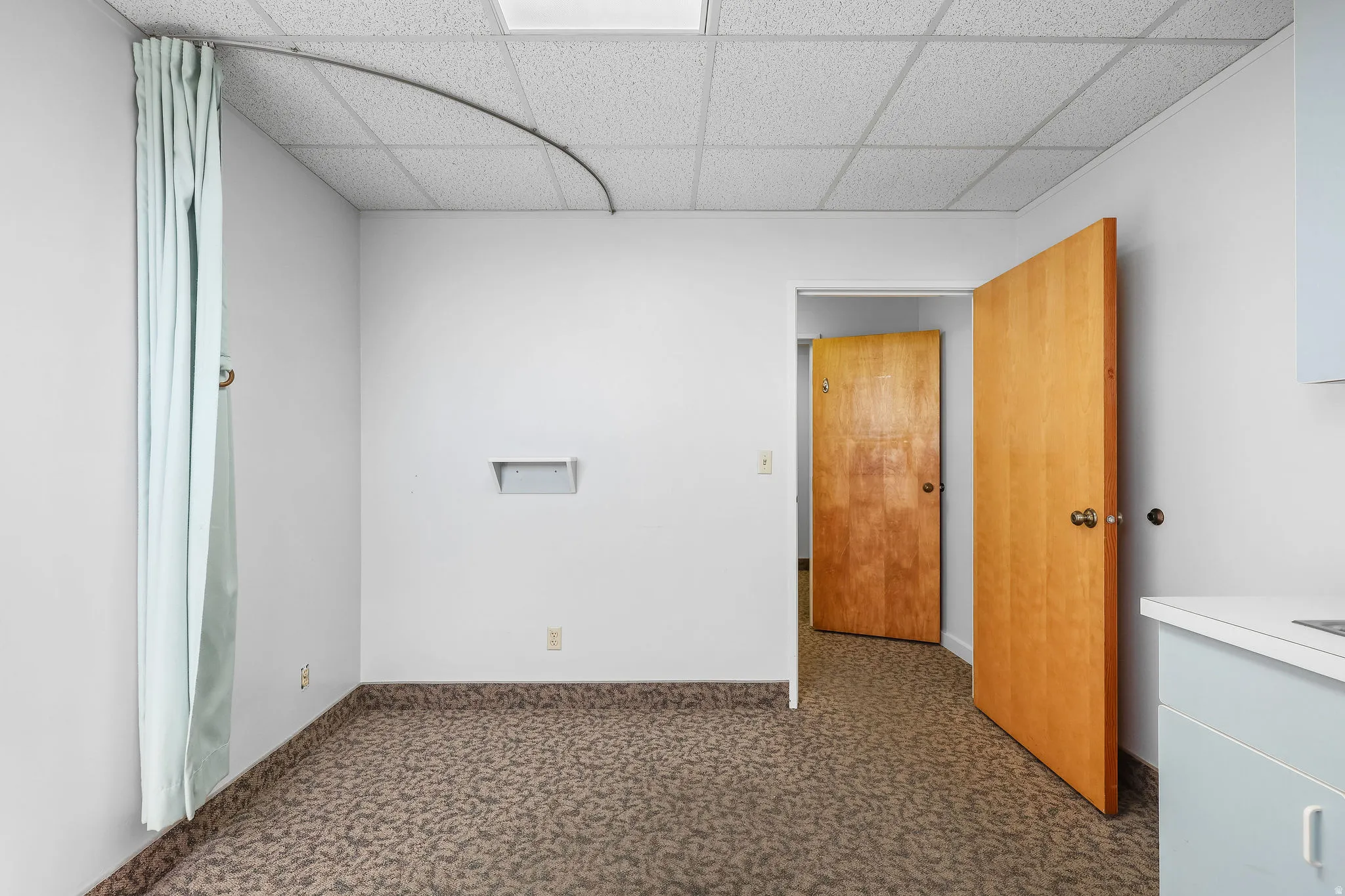 Interior space featuring patterned carpet flooring and a drop ceiling