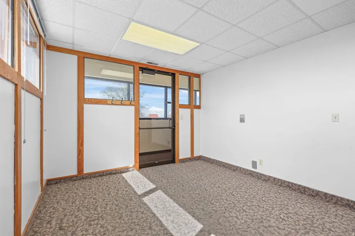 Carpeted room featuring a drop ceiling with recessed lighting
