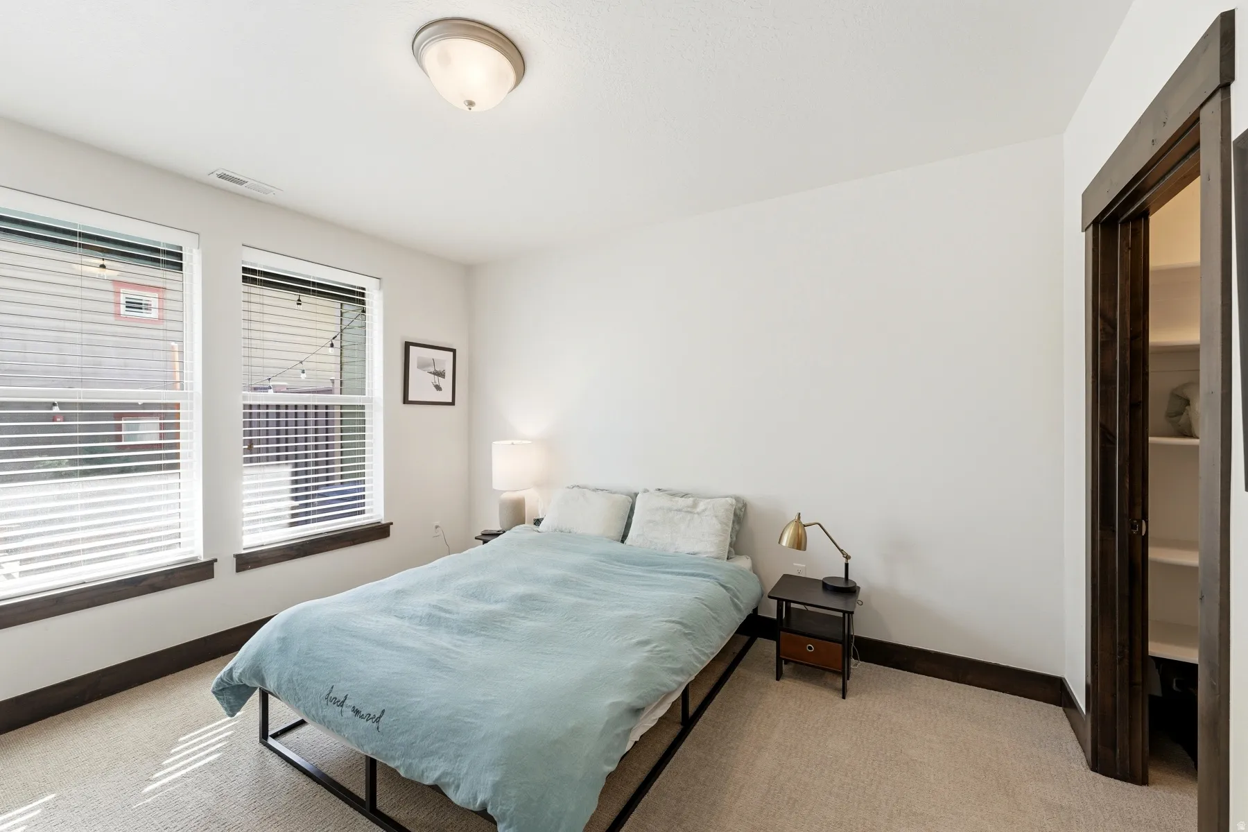 Room featuring two windows with horizontal blinds, providing ample natural light
