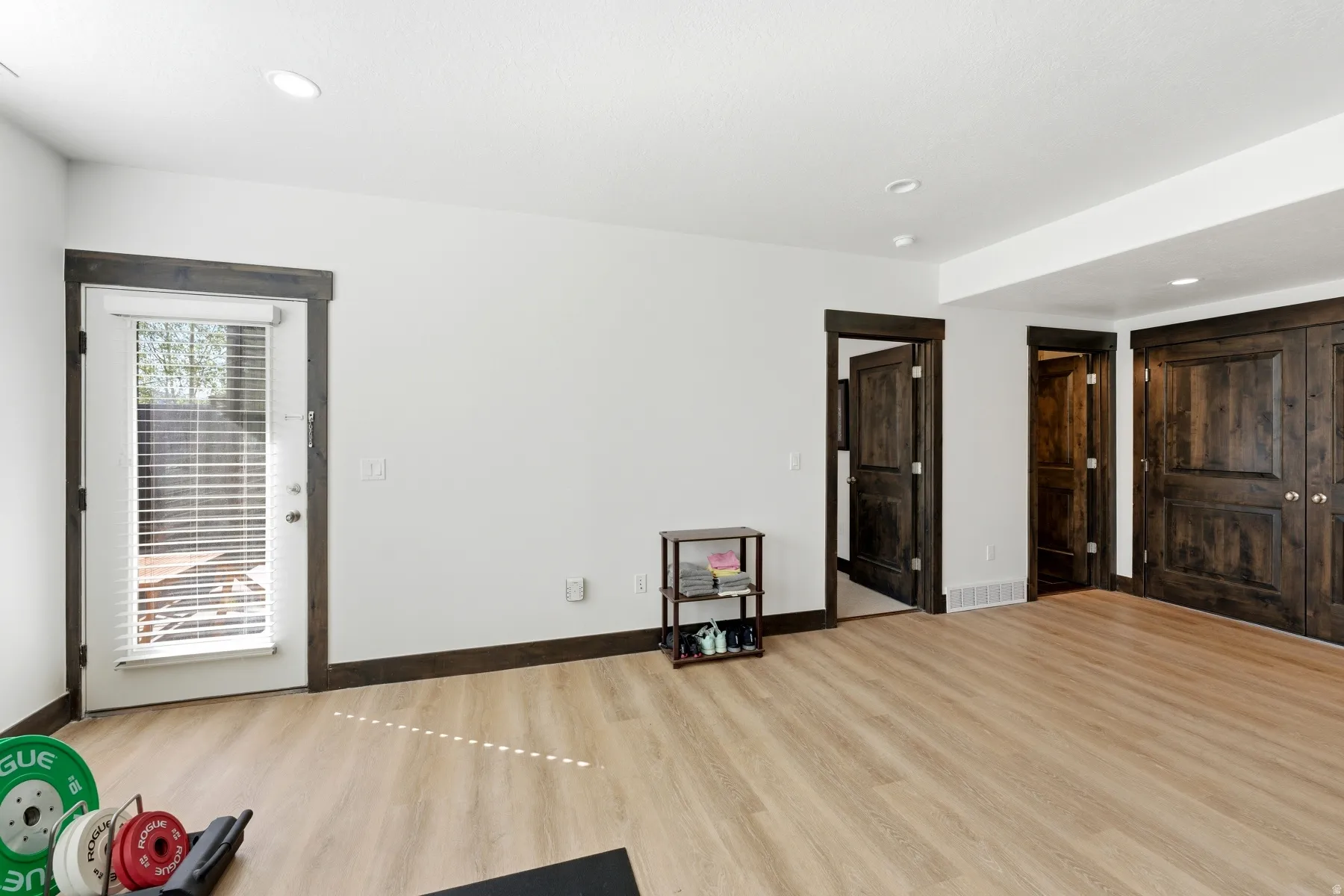 Bright room featuring light wood-finish flooring and recessed lighting