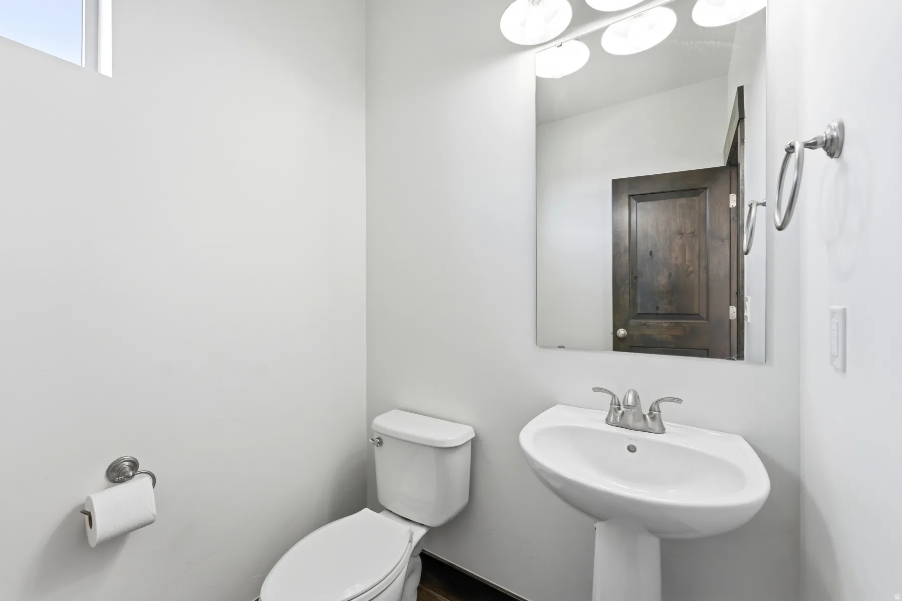 Pedestal sink with chrome-finish faucet and wall-mounted mirror