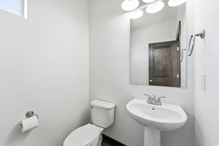 Pedestal sink with chrome-finish faucet and wall-mounted mirror