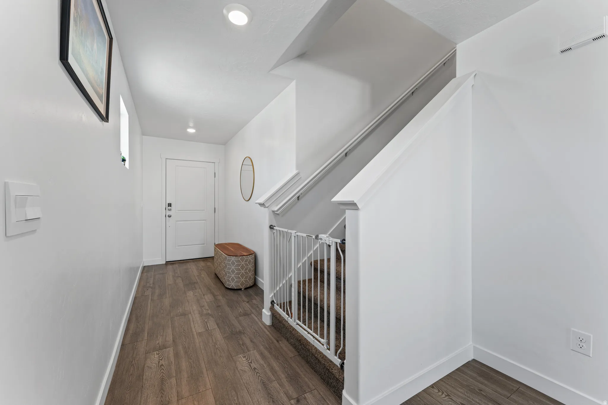 Entryway featuring wood-finish flooring, white paneled interior door, and recessed lighting